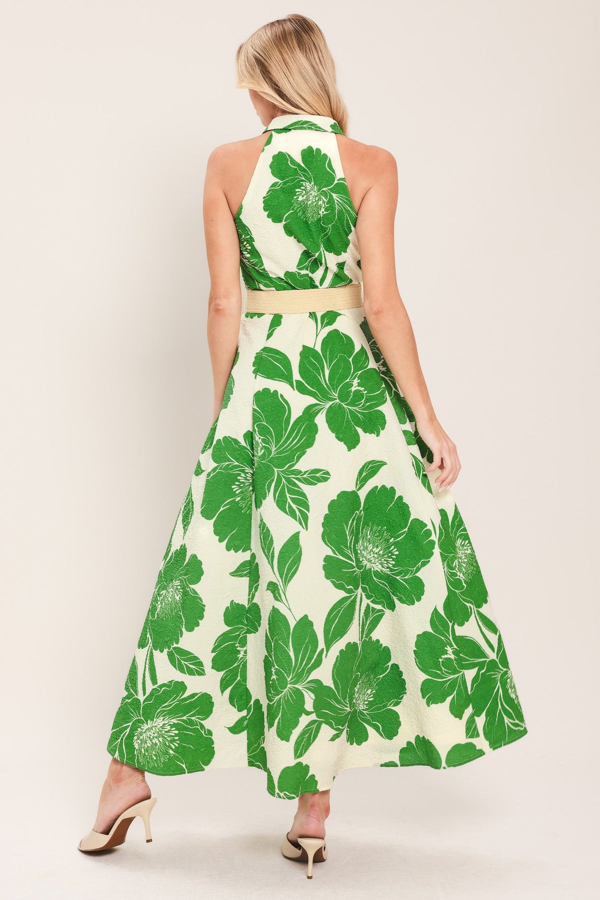 Woman wearing a green floral dress on a white background