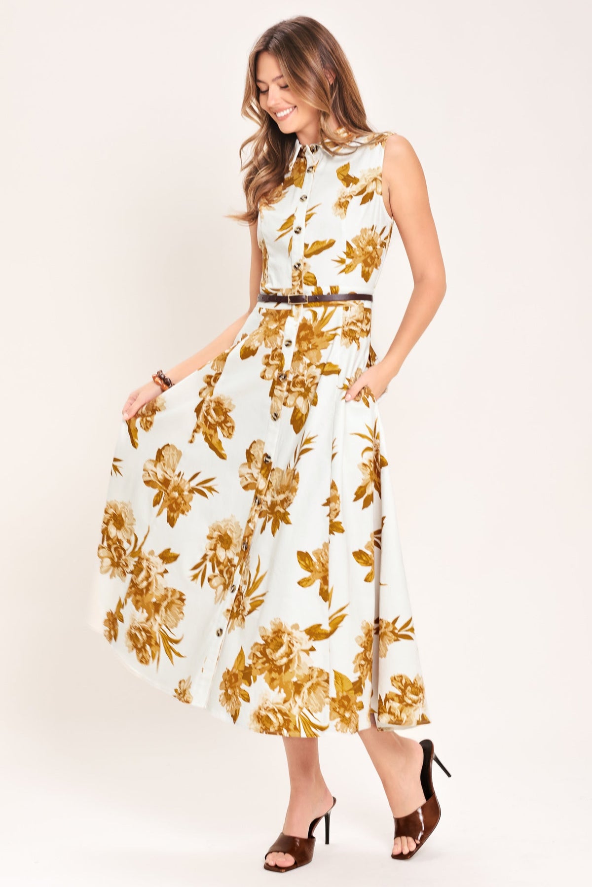 Woman wearing a floral dress with gold flowers on a white background