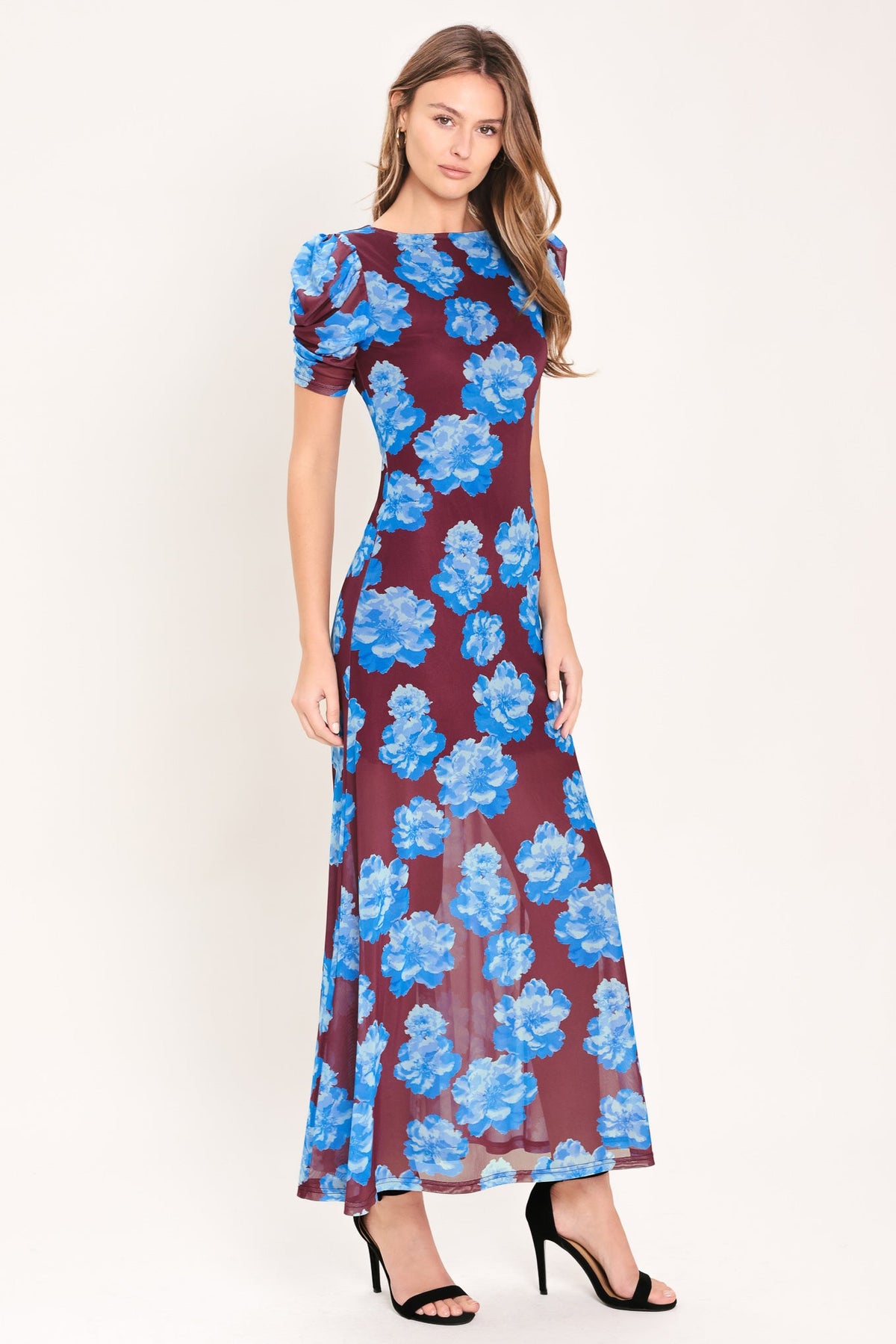Woman wearing a floral dress with blue flowers on a white background