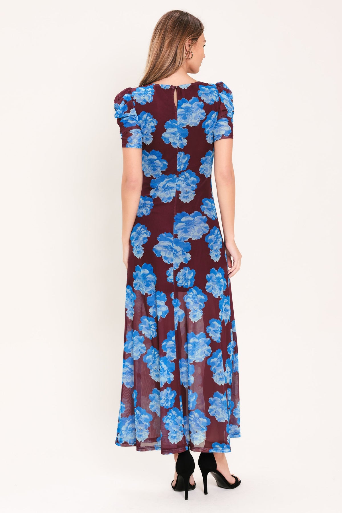 Woman wearing a floral dress with blue flowers on a white background