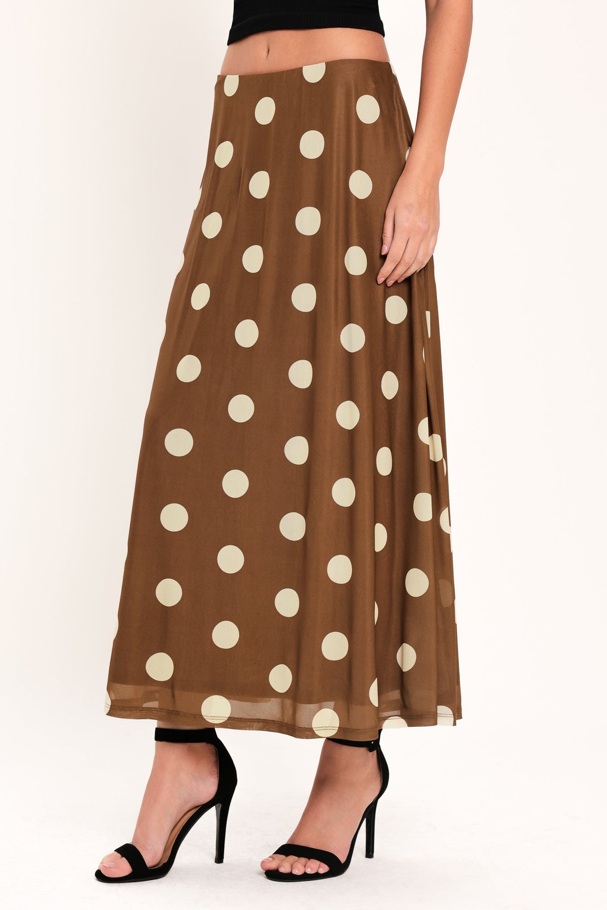 Brown polka dot skirt worn by a person on a white background