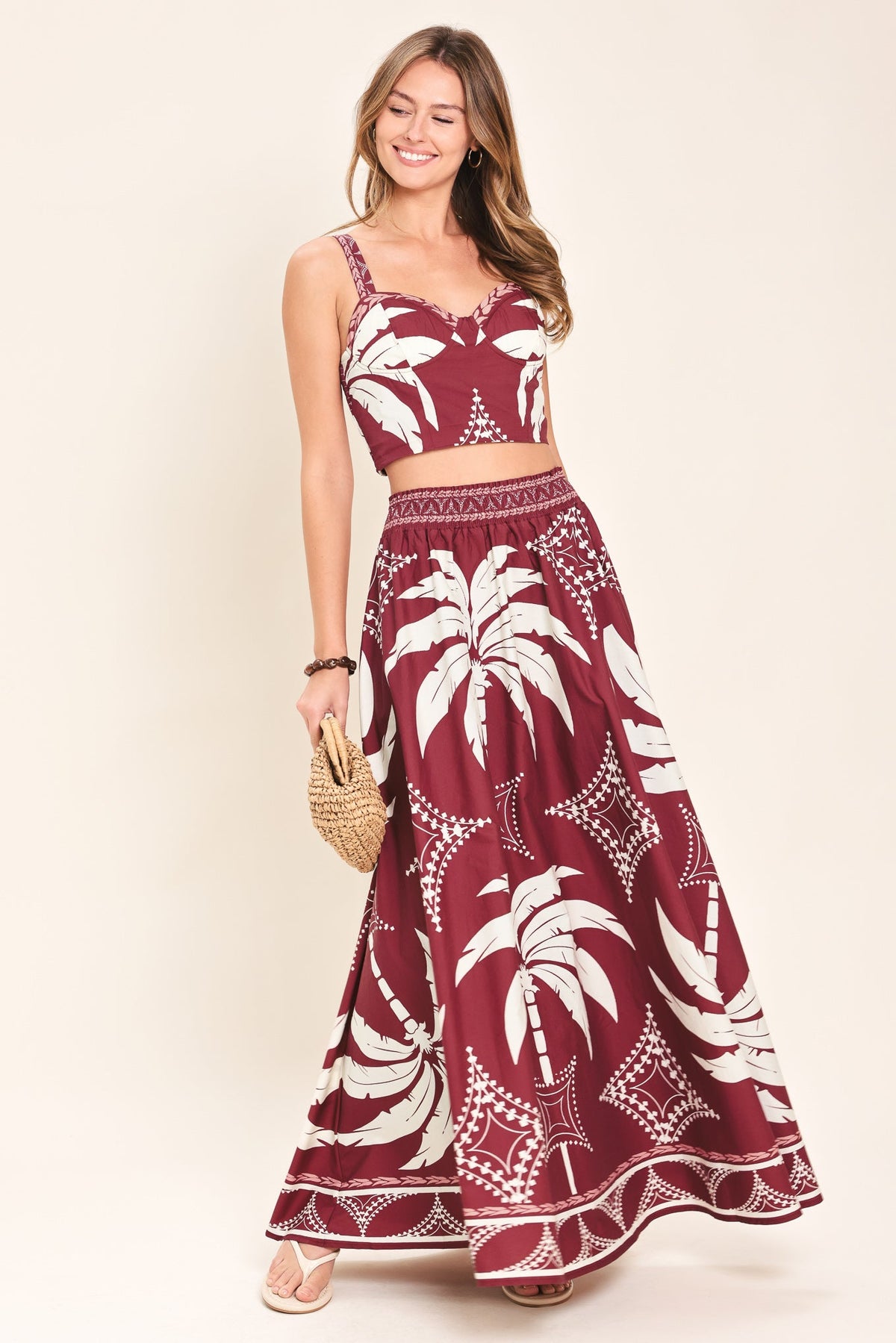 Woman wearing a red and white patterned two-piece outfit on a beige background