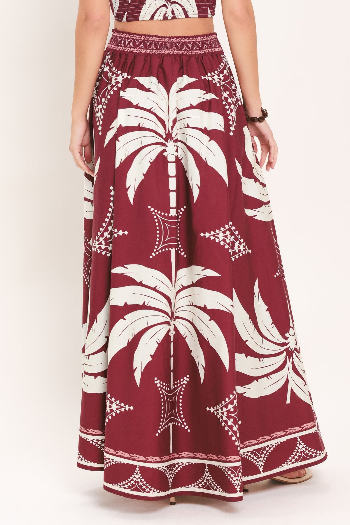 Maroon skirt with white palm tree pattern on a white background