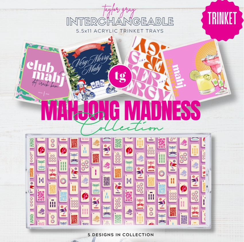 A promotional graphic for the Taylor Gray Interchangeable 'Trinket' collection, showing several colorful acrylic trinket tray designs floating above a larger view of a pink mahjong-themed tray labeled 'Mahjong Madness Collection'. Text at the bottom reads '5 DESIGNS IN COLLECTION'.