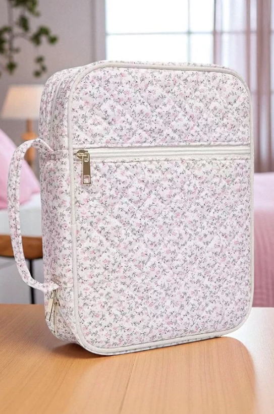 Floral-patterned bag on a wooden surface with a blurred indoor background