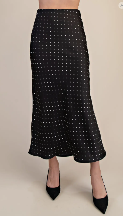 Black polka dot skirt on plain background