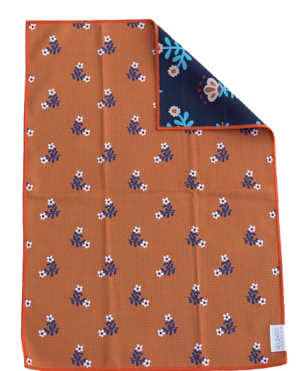 An orange textured pocket square with a repeating pattern of small white and blue flowers, shown folded to display both sides. One side features the orange floral pattern, and the reverse side is dark navy blue with a light blue and white floral design.