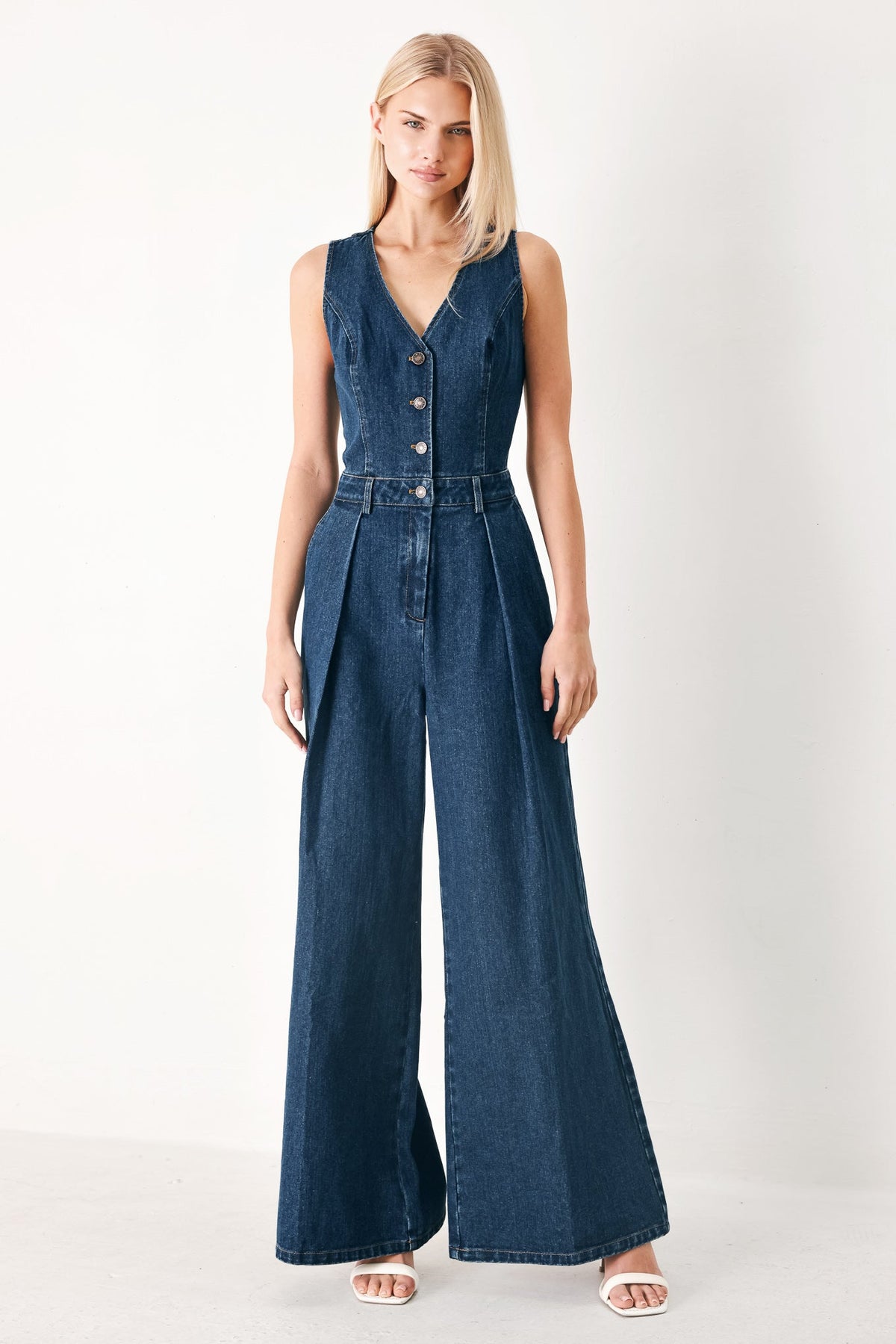 Woman wearing a denim jumpsuit on a white background