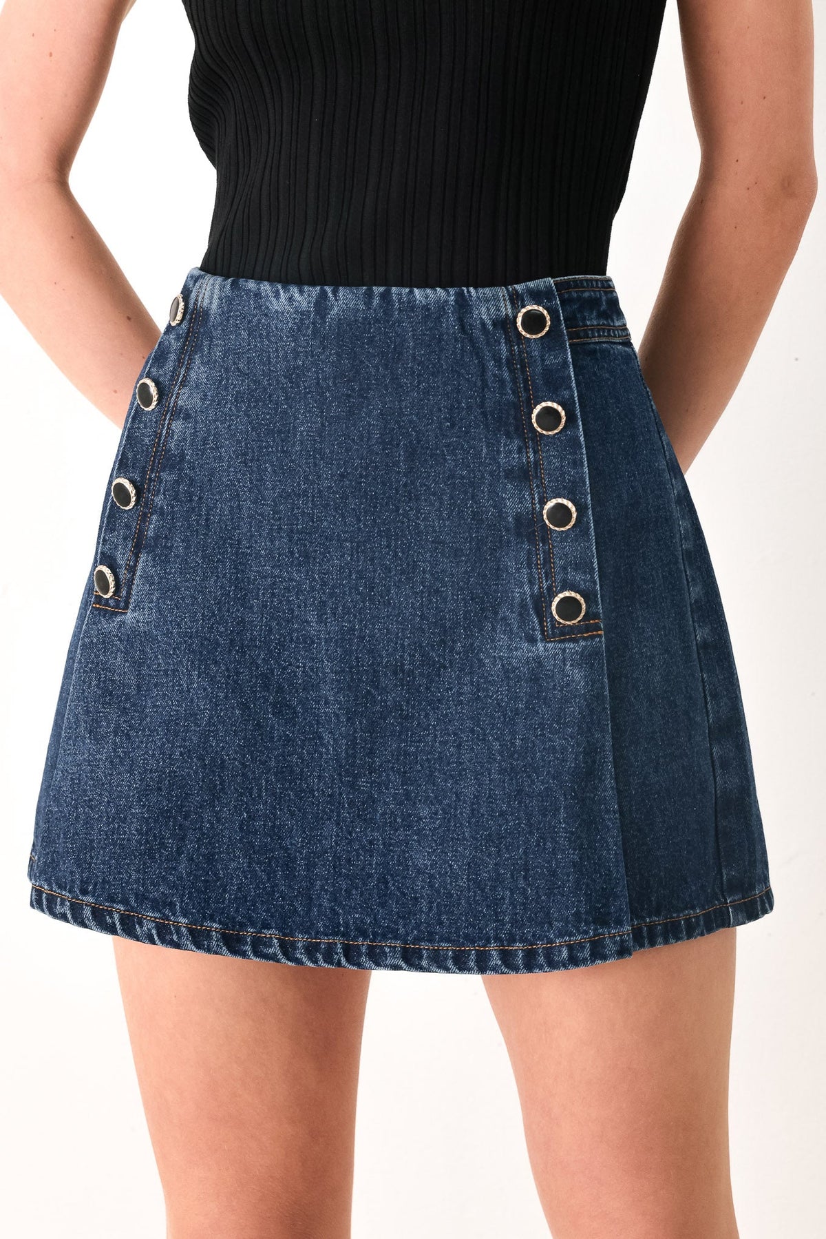 Blue denim skirt with button details on a white background