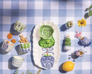 Decorative arrangement of small plants and a lemon on a checkered tablecloth