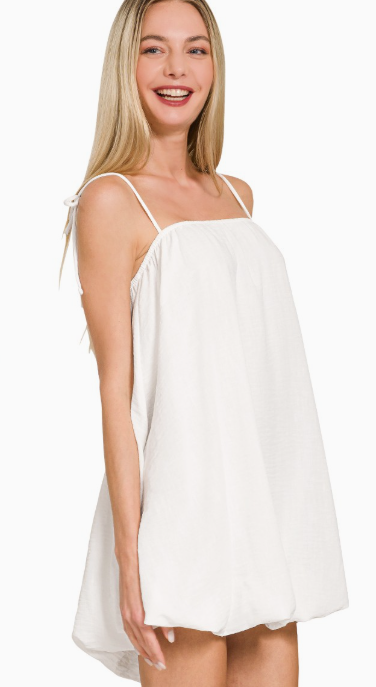 Woman wearing a white dress with thin straps on a white background