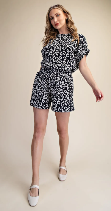 Woman wearing a black and white patterned outfit on a beige background