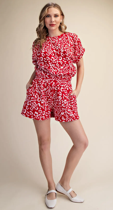 Woman wearing a red and white patterned dress on a beige background