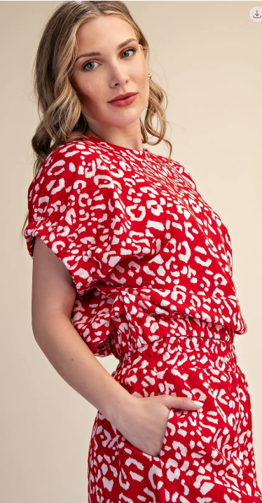 Woman wearing a red dress with white pattern on a beige background