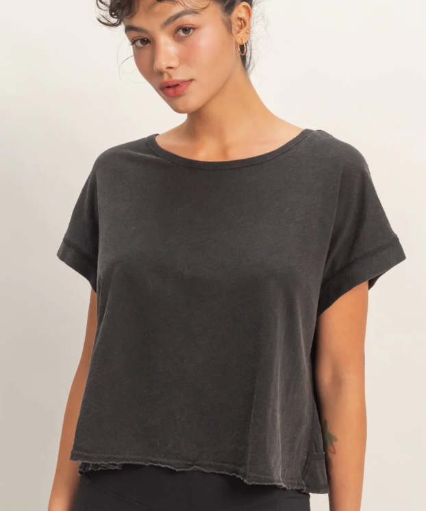 Woman wearing a dark gray t-shirt against a plain background