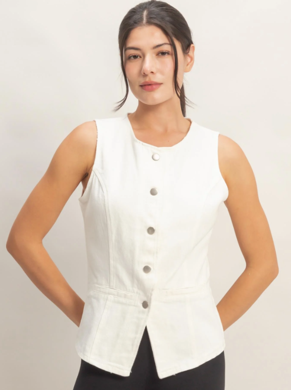 Woman wearing a white sleeveless button-up top against a plain background