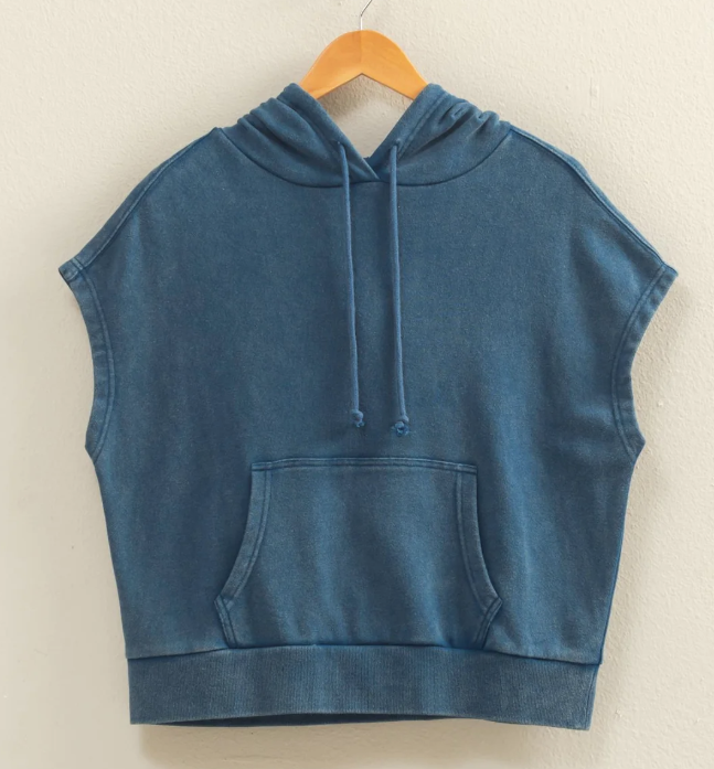 Blue sleeveless hoodie on a wooden hanger against a beige background