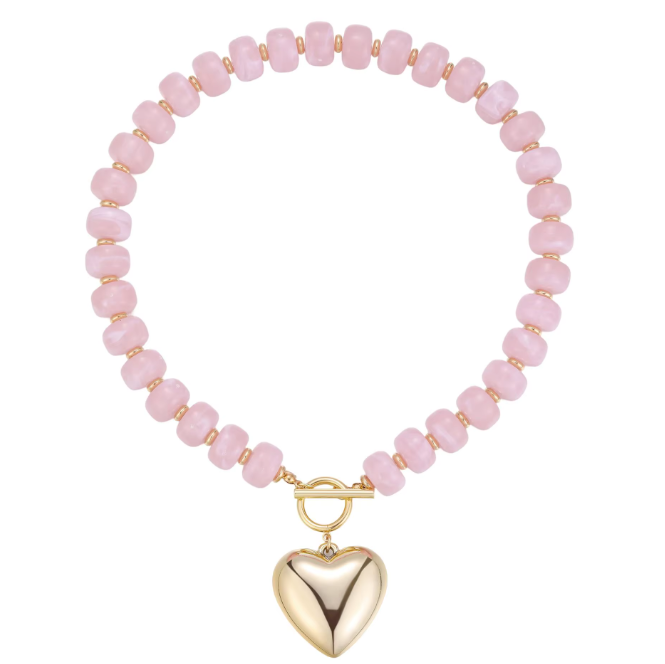 A pink beaded stretch bracelet with faceted round beads and a polished gold heart-shaped toggle clasp, shown on a plain white background.