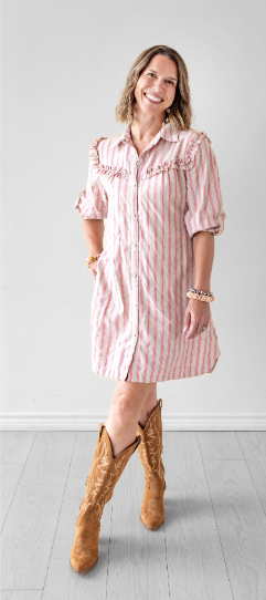 woman wearing a pink and white dress with cowboy boots
