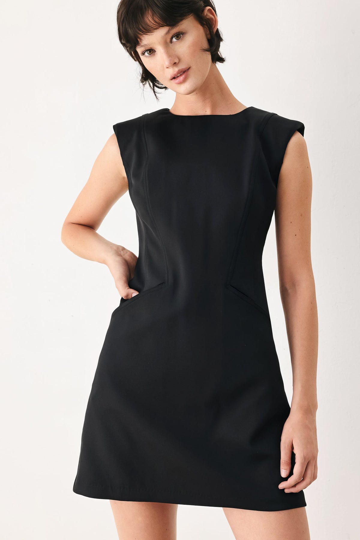 Woman wearing a black dress against a white background