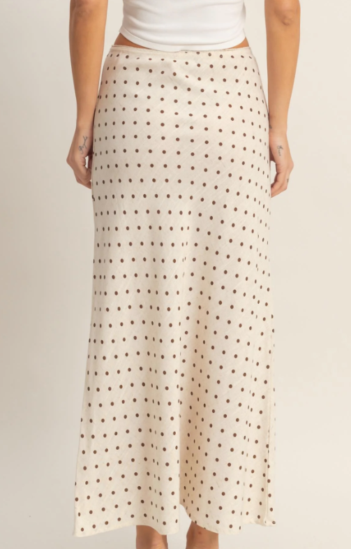 Person wearing a polka dot skirt on a plain background
