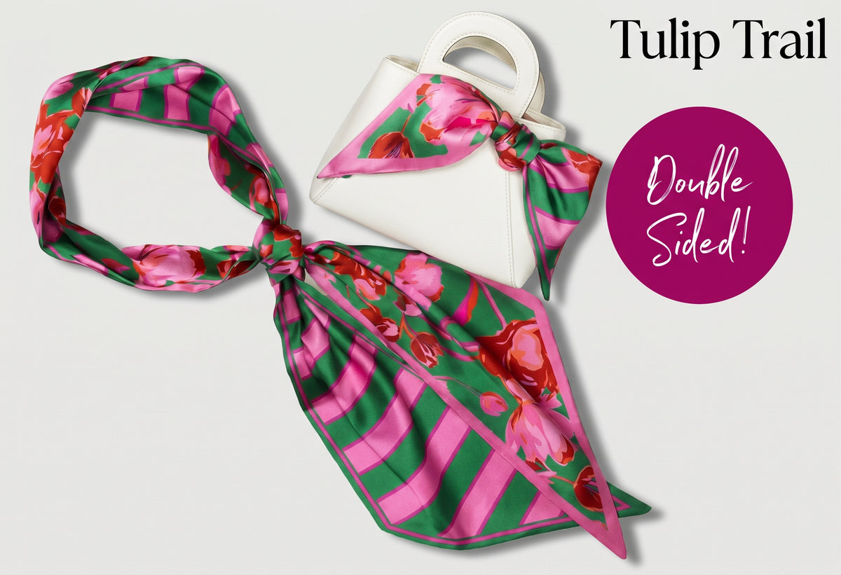 A double-sided silk scarf with a tulip and stripe pattern in pink, green, and red, displayed next to a white handbag. The text 'Tulip Trail' and 'Double Sided!' are printed on the image.