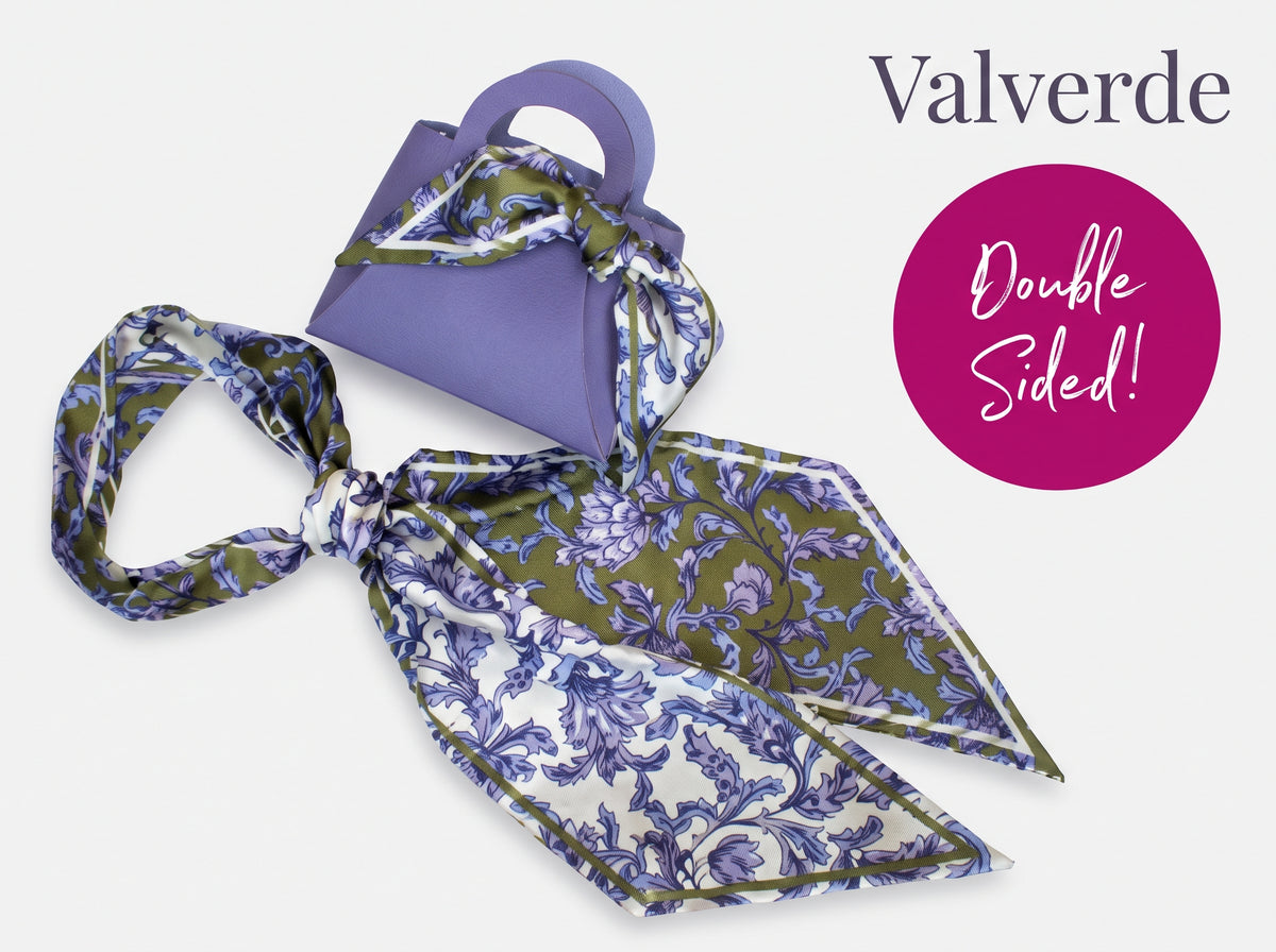 A Valverde double-sided silk scarf with a blue and purple floral pattern on an olive green and white base, displayed next to a purple handbag. A magenta circle on the right highlights 'Double Sided!' and the brand 'Valverde' is written at the top.