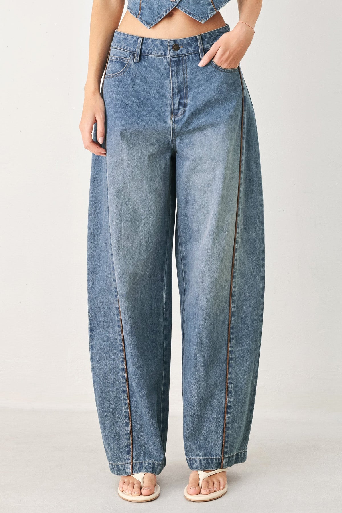 Person wearing blue jeans on a plain background