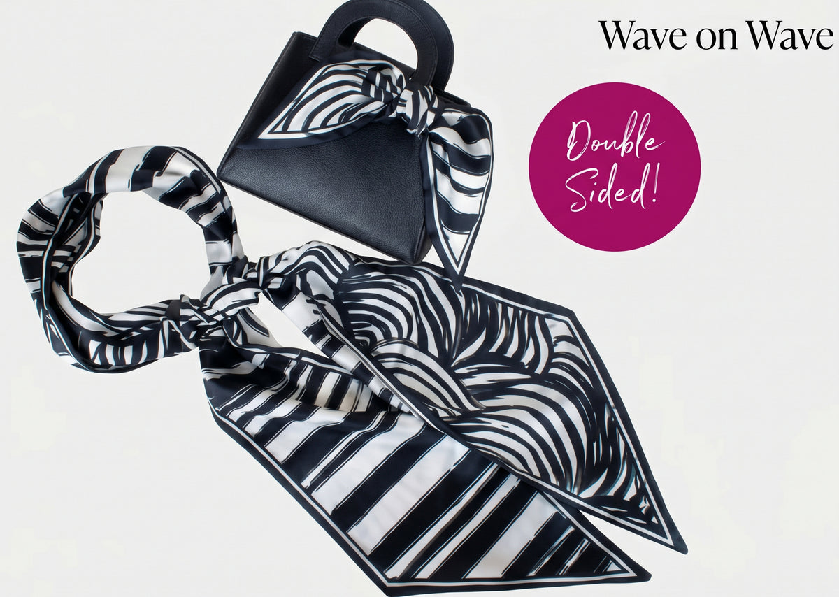 A double-sided silk scarf with a black and white zebra-stripe pattern, shown styled with a black handbag and a pink circular badge that reads 'Double Sided!'.