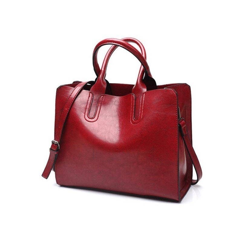 A red leather tote bag with dual top handles and a detachable shoulder strap, shown on a plain white background.