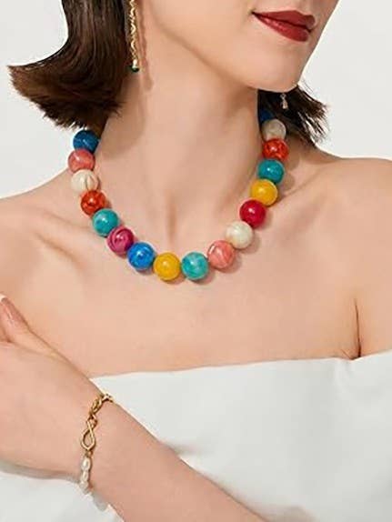 Colorful beaded necklace worn by a model with a plain background