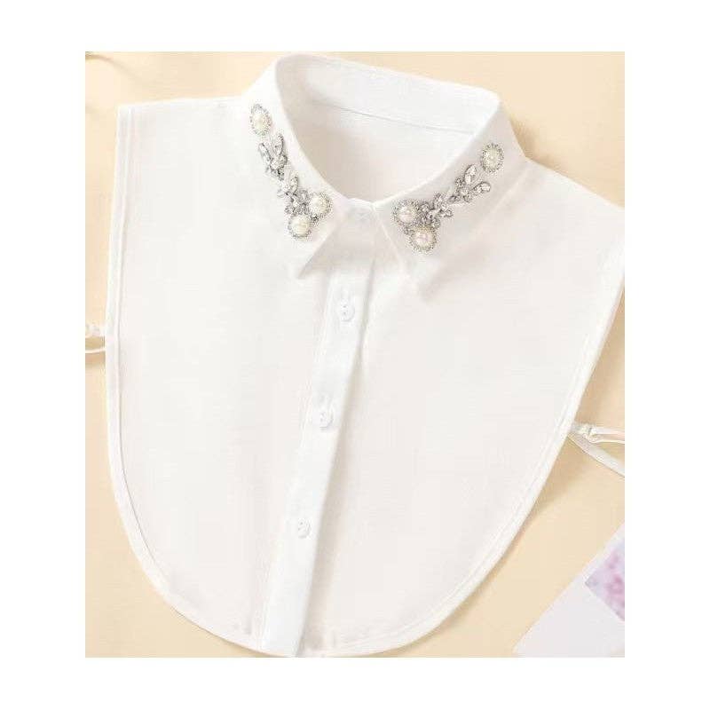 White shirt collar with decorative pearls and crystals on a beige background