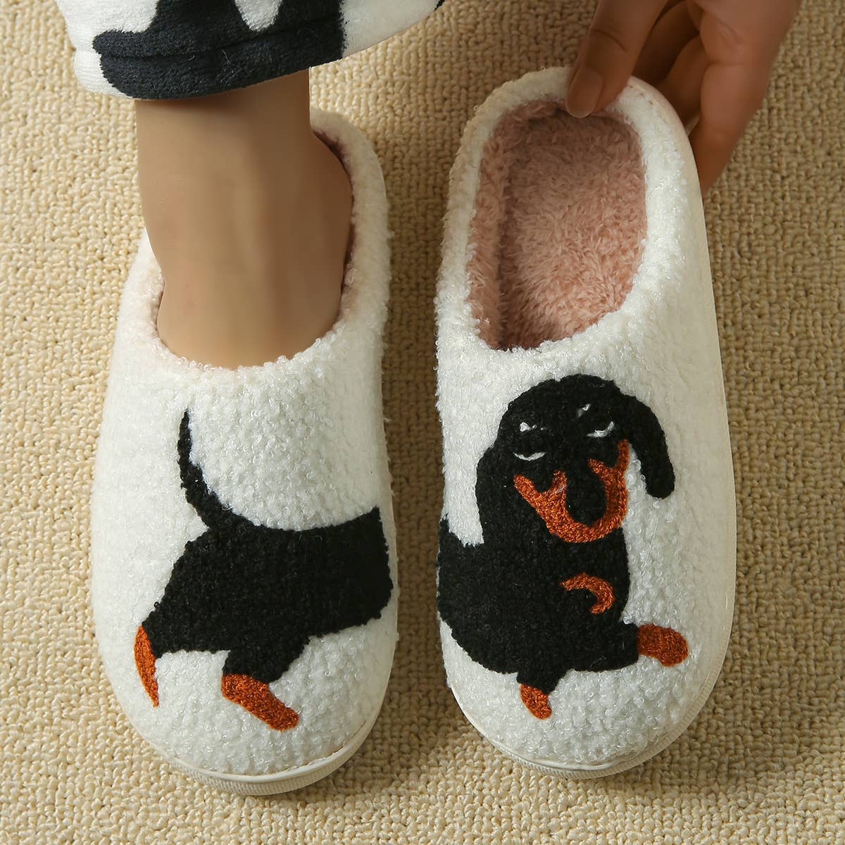 White slippers with dachshund design on a beige carpet