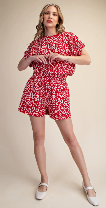 Woman wearing a red and white patterned outfit on a beige background